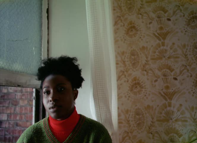 A woman sitting at her open window sighing and looking frustrated and bored