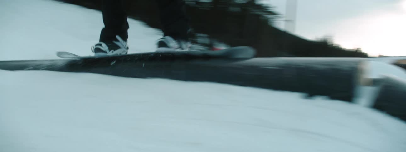 Male snowboarder rides snowboard downhill in snowboarding holiday resort