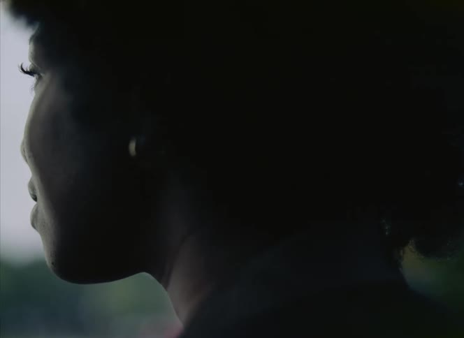 Back of the womans head with curly hair and earrings
