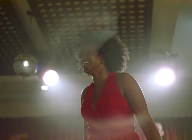 A woman looks around her and then smiles