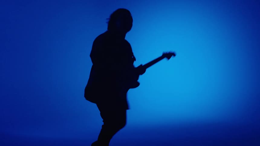A man is dancing and playing the guitar instrument