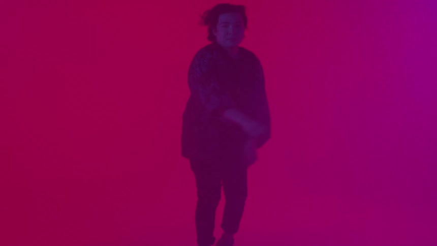 A man jumps twirls and dances with red light glowing