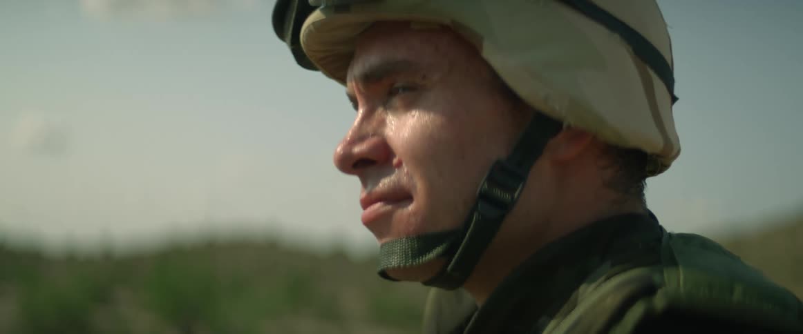 Sunlight shines on the face of a man outside wearing a helmet as he turns his head