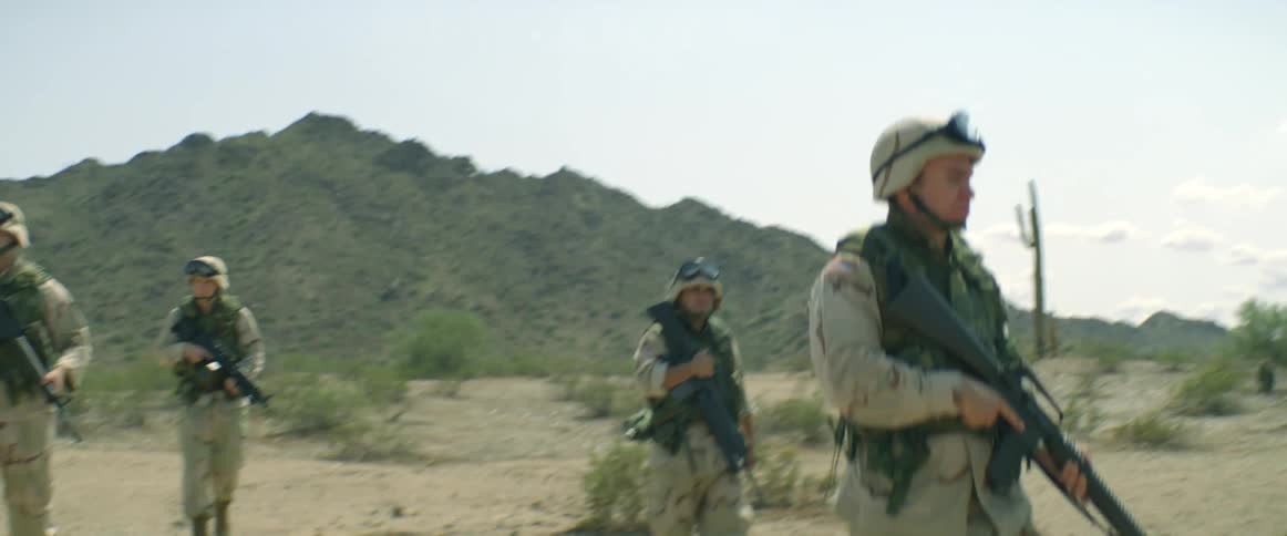 Army soldiers are outdoors in a desert area