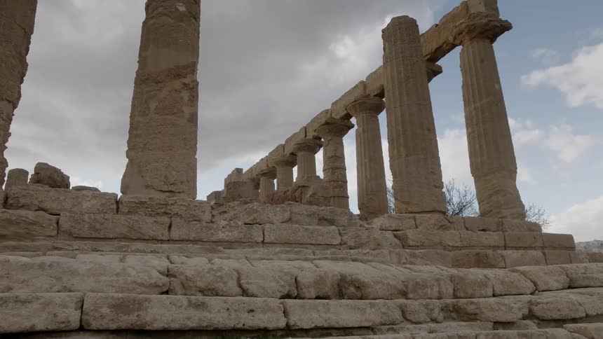 Clouds float over stone pillars and ruins