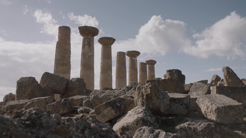 Clouds float over stone pillars and ruins