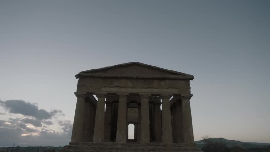 The temple of concordia ruins stand against a dawn sky