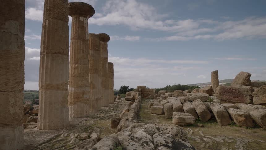 Ruins with stone pillars stand in a rural area