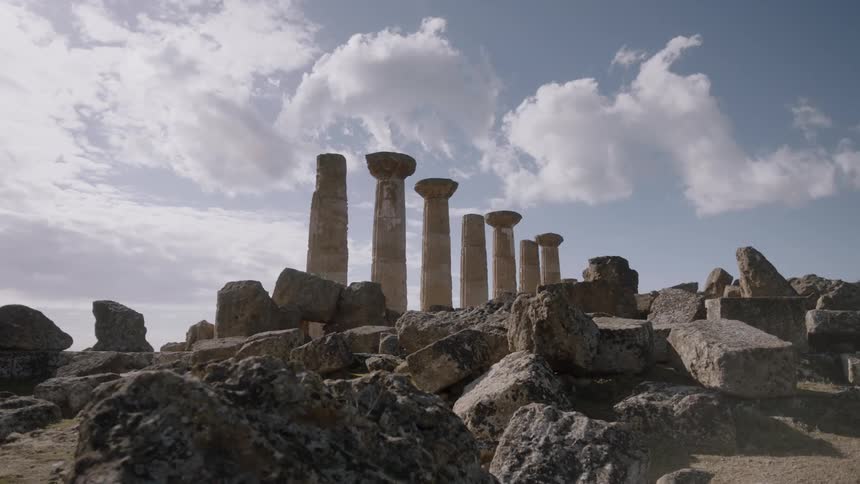 Clouds float over stone pillars and ruins