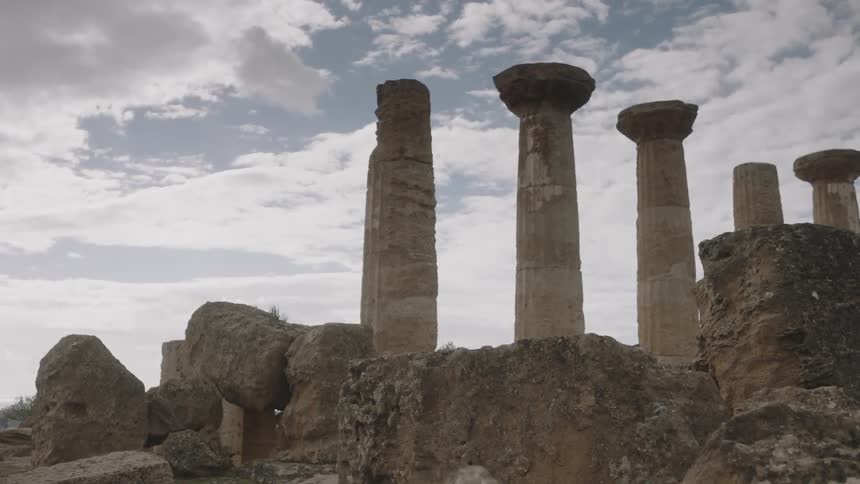 Clouds float over stone pillars and ruins