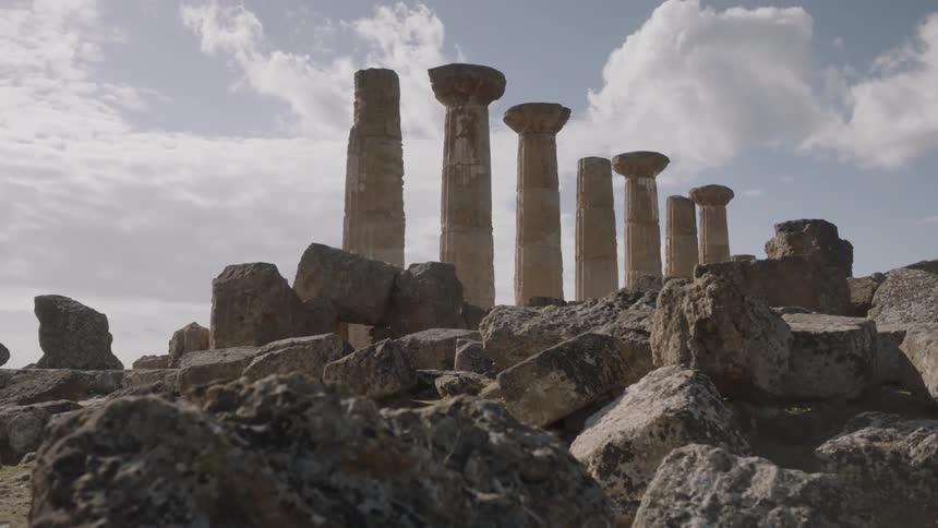 Clouds float over stone pillars and ruins