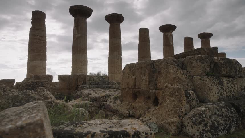 Clouds float over stone pillars and ruins