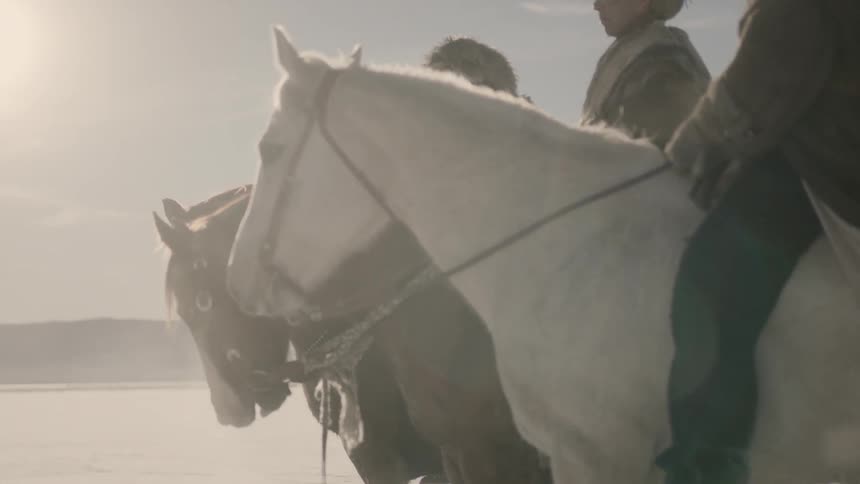 Three men sit on their horses in a cold setting