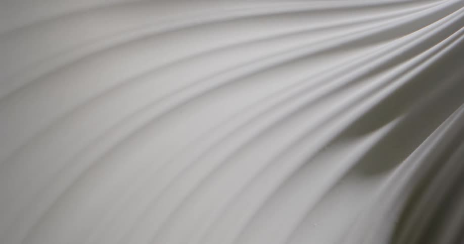 A shadow moves over a rippled white fabric