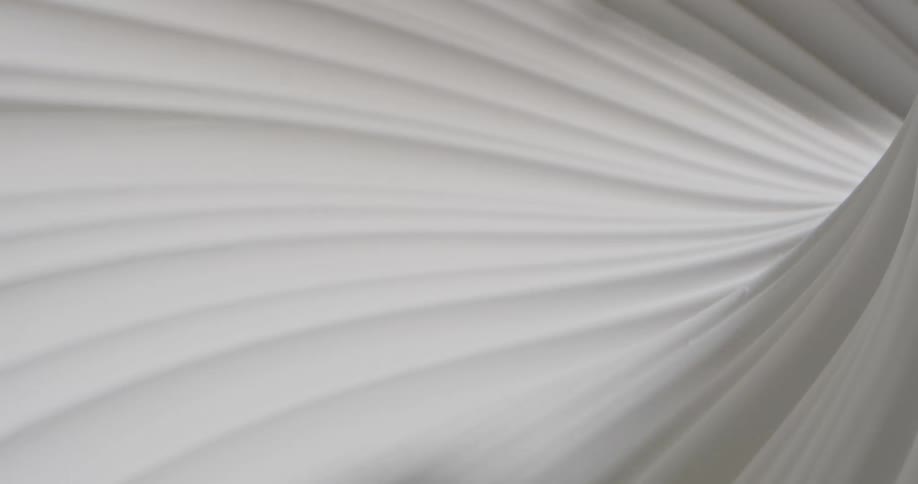 A white and rippled material is endlessly rotating