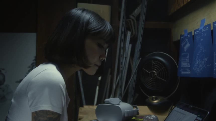 A young woman in an office looks at her laptop