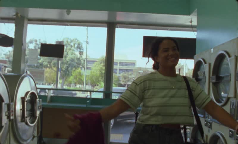 A woman hugs a man in the laundromat