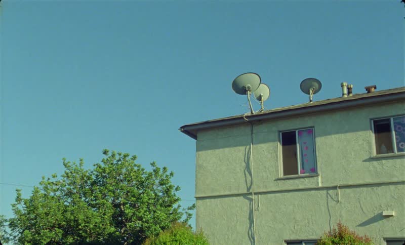 A house that is located in a small town in the summer time
