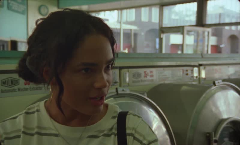 A young hispanic woman is washing her clothes at a laundromat