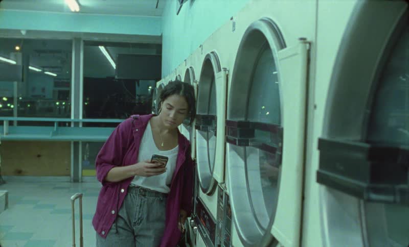 A woman makes a call in the laundromat