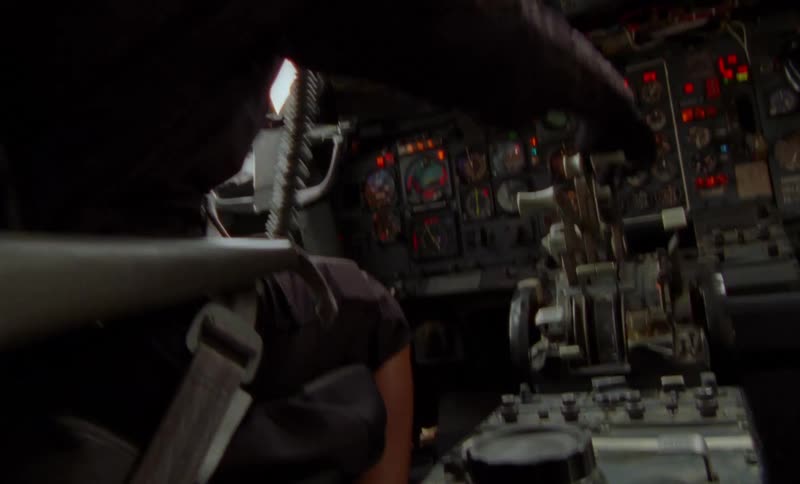 A pilot sits in the cockpit as his plane is shaking and he quickly moves levers and controls