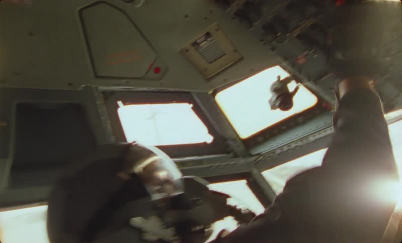 A man is frantically pressing buttons in the cockpit