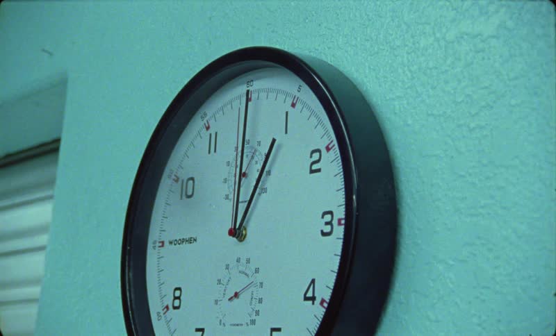 Round clock with black frame on the wall of building