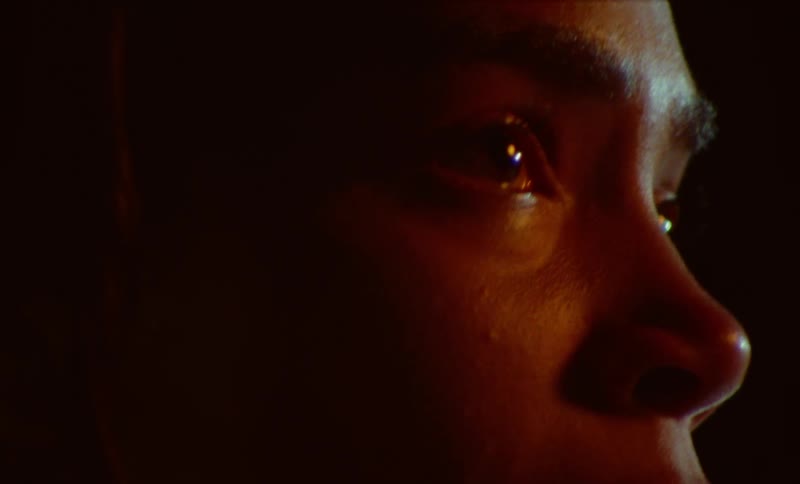 Close up of womans face crying and looking at light