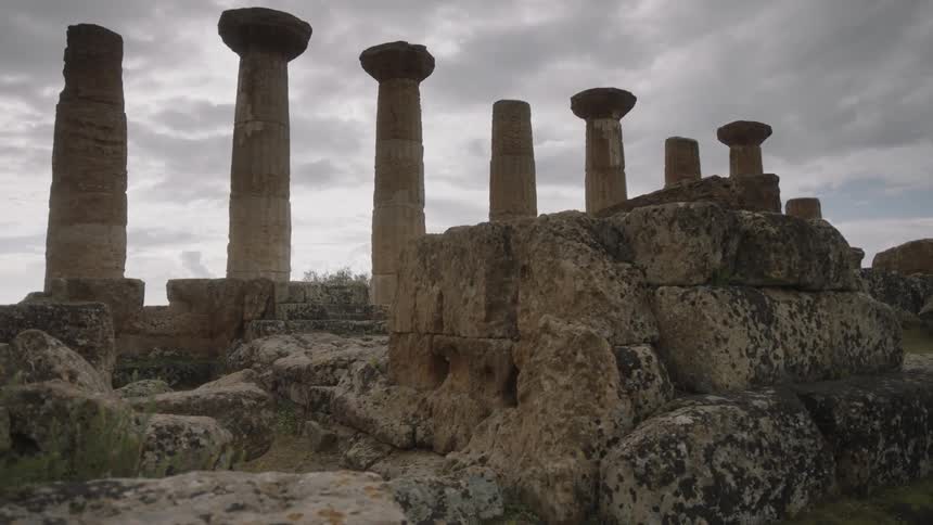 Columns and ruins from a stone foundation sit and decay