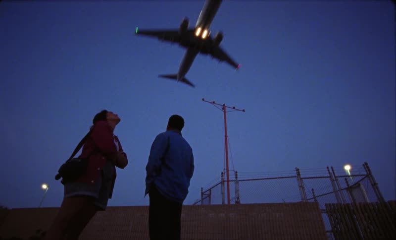 Two people watch the plane fly over