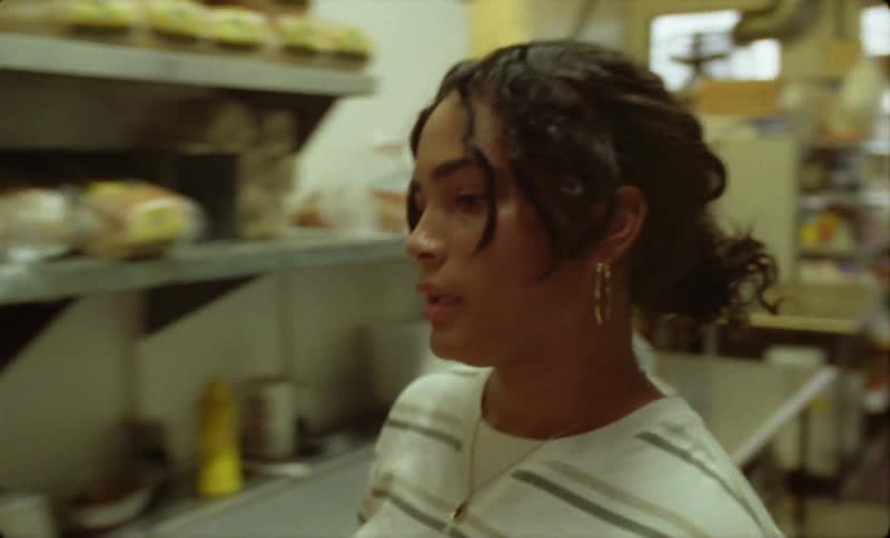 Woman carries plate in to restaurant kitchen and starts talking