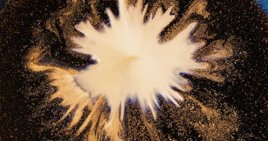A cream color blossom shape expands into a circle then ripples