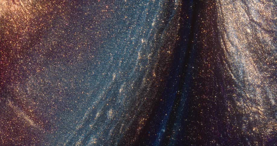 Glitter shimmers on the surface of a dark blue liquid