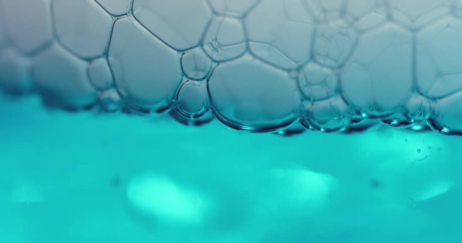 Bubbles rising and floating in blue liquid