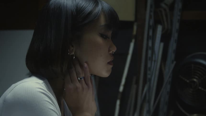 A young woman rubbing her face and neck indoors