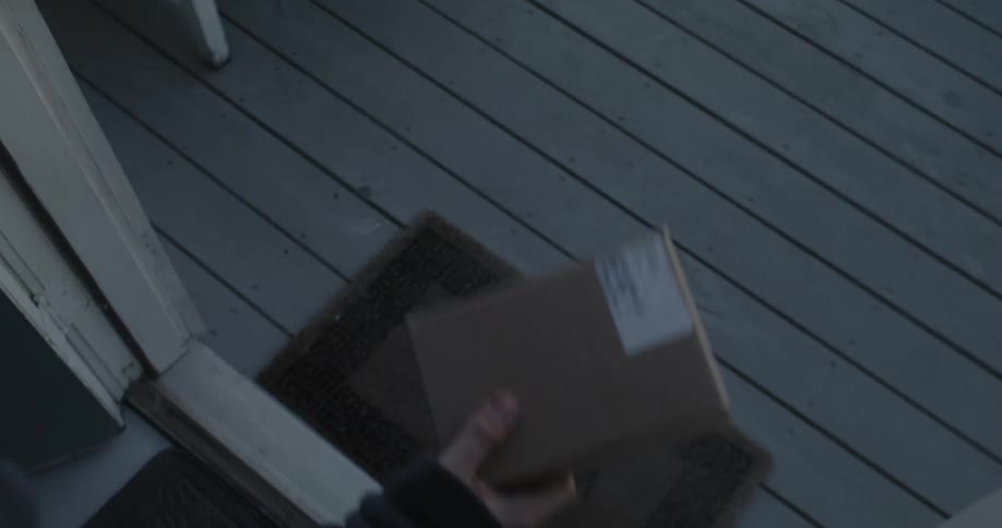 Man with bathrobe picks up a small package