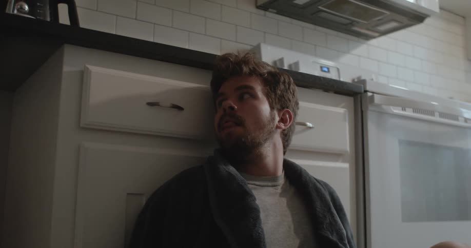 A white man is inside of his house and he has a scared look on his face