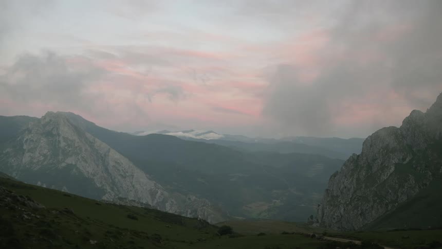 The sky is pink at dawn over inhospitable Cantabrian mountains