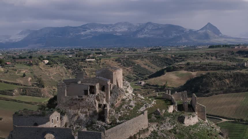 A broken down castle sits on a hilltop