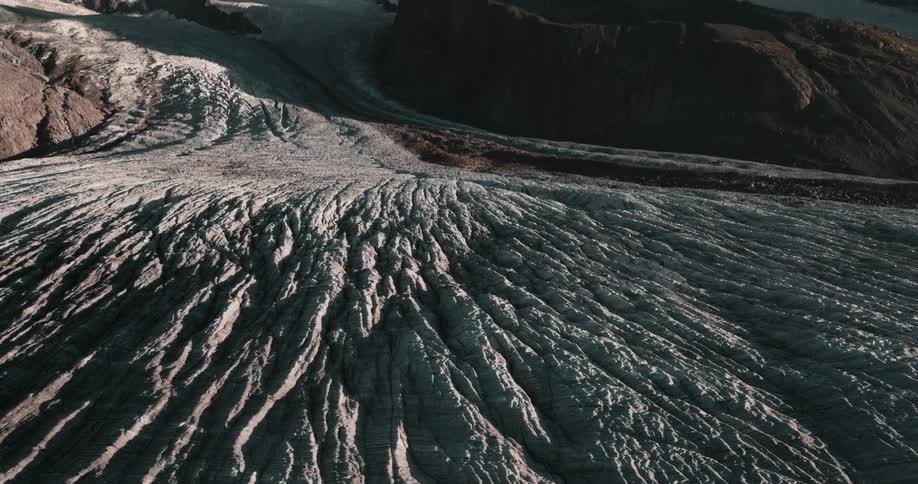 A blanket of snow covers the peaks and sides of a mountain range along the coast