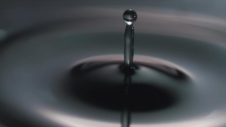 A water droplet falling into a body of water and causing ripples