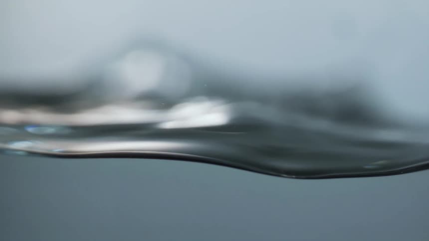 The surface of water subsides and rises in waves