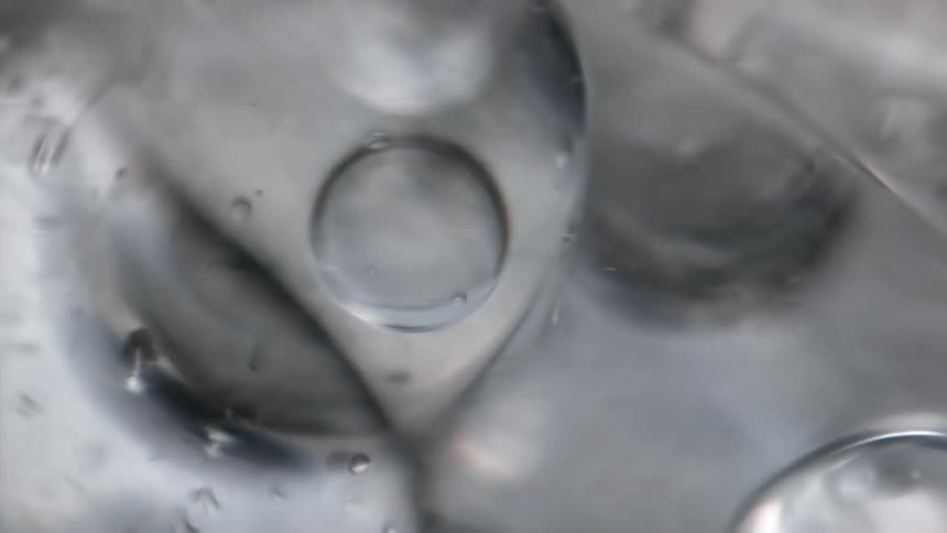 Extreme close up of air bubbles and small ripples on the surface of the water