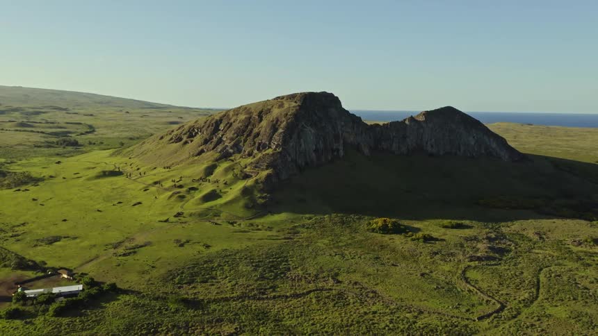 An aerial view of a mountain surrounded by land in nature