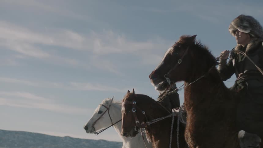 Asian men riding horses