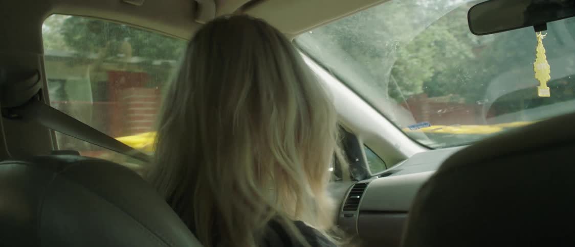 A woman is talking and smiling while riding in the car