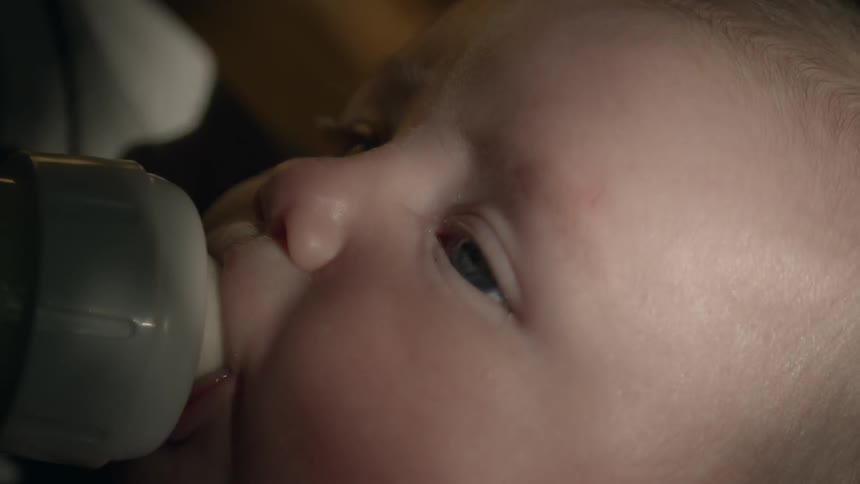 Mother feeds newborn baby with bottle