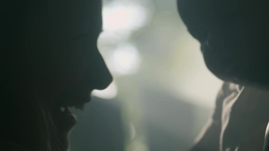 Mother holding baby up is silhouetted against the sunlight streaming through windows