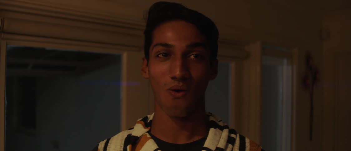 Man with white hoodie eats candy smiling and talking