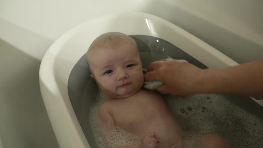 A mother is giving a baby a bath
